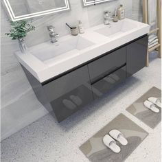 a bathroom with two sinks, mirrors and slippers on the floor in front of it