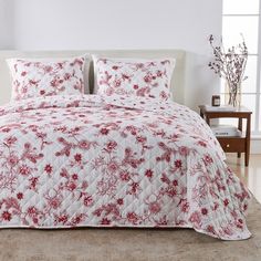 a red and white comforter on a bed in a room