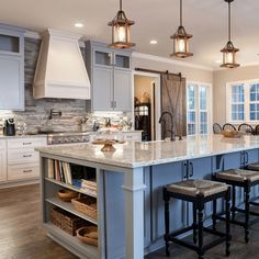 a large kitchen with an island in the middle and lots of stools around it