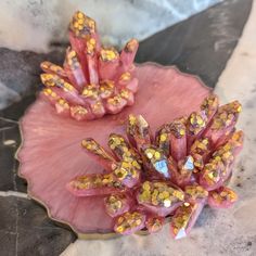 two pink and gold decorative objects sitting on top of a marble slabd countertop