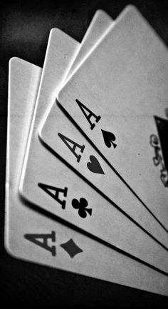 four playing cards are stacked on top of each other in black and white photo,