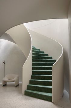 a green staircase leading up to a white chair