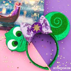 the green mouse ears are decorated with purple and gold sequins, along with an image of disney's princess