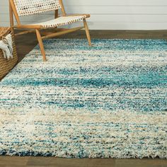 a blue and white rug with a chair in the background