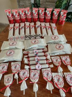 the table is full of red and white candy bags with ribbons tied around each bag