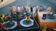 a group of young men standing next to each other in front of musical equipment on a street