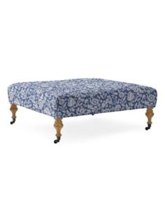 the footstool is made from wood and has a blue floral pattern on it