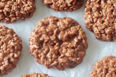 chocolate cookies are arranged on top of white paper