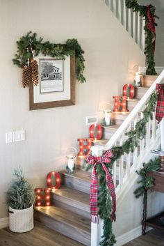 christmas decorations on the banisters and stairs in a home decorated with greenery