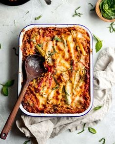 a casserole dish with spinach, cheese and sauce in it on a table