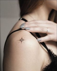 a woman's arm with a small star tattoo on her left shoulder and right hand