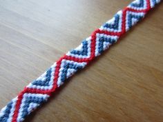 a red, white and blue bracelet sitting on top of a wooden table