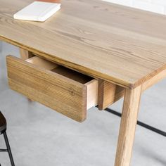 a wooden table with two drawers underneath it and a chair next to it on the floor