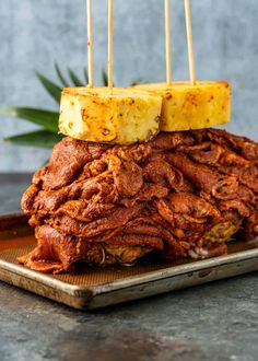 a pile of food sitting on top of a metal tray with toothpicks sticking out of it