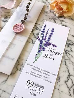 the wedding stationery is laid out on the marble table with flowers and wax stamp