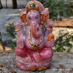 an elephant statue sitting on top of a rock