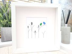 a white frame with three flowers in it