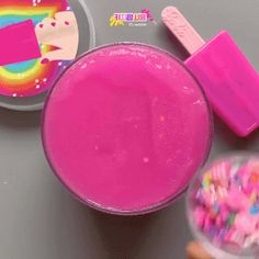 there is a bowl of sprinkles next to a plastic container with a pink substance in it