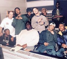 a group of young men posing for a photo in front of a sound mixing desk