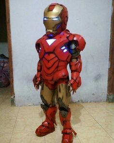 an iron man costume is standing on the floor in front of a white wall and tiled floor