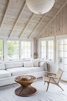 a living room with white furniture and wood paneling on the walls is featured in instagram