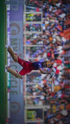 a man flying through the air on top of a pair of skis in front of a crowd