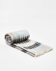 two towels folded on top of each other in front of a white background with black and grey stripes