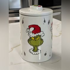 the grin face canister is decorated with santa claus's hat