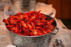 a bucket filled with red craws sitting on top of a table next to a newspaper