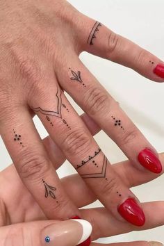 two fingers with tattoos on them, one has an arrow and the other has stars