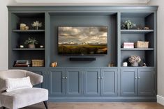 a living room with built in bookshelves and a large television on the wall