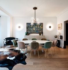 a dining room table with chairs and a cow rug on the floor in front of it