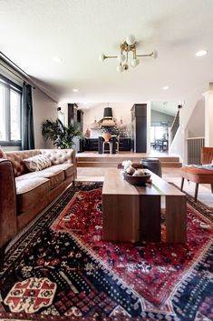 a living room filled with furniture and a rug on top of a wooden coffee table