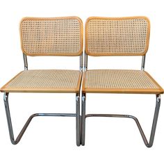 two chairs sitting next to each other on top of a white surface with metal legs