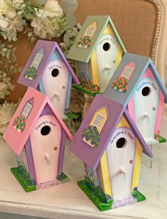 four colorful bird houses sitting on top of a table