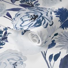 a blue and white floral wallpaper with large flowers on the back side of it