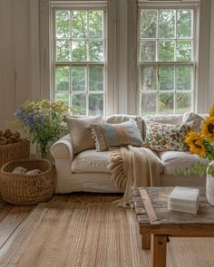 a living room with sunflowers in the window and wicker baskets on the floor