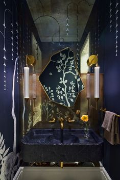 the bathroom is decorated in blue and gold with an art deco mirror above the sink