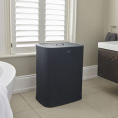 a black trash can sitting in the middle of a bathroom