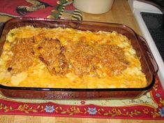 a casserole dish with meat and cheese in it sitting on a table next to a microwave