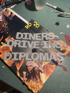 a table topped with a sign and other items on it's side that says diners drive - ins diplomas