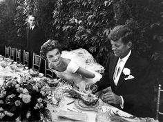 an old black and white photo of a bride and groom cutting their wedding cake