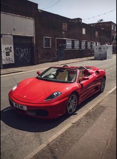 a red sports car is parked on the street