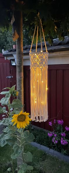 a light hanging from a tree next to a sunflower