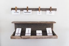 a wooden shelf with calendars hanging on it