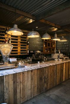 an empty bar with lots of wine bottles on the wall and lights hanging from the ceiling