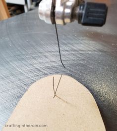 a piece of wood being worked on with a driller and some thread in front of it