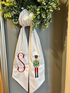 a door hanger decorated with an embroidered monogram and the letter s on it