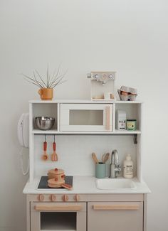 a kitchen with white cabinets and wooden utensils on top of the countertop