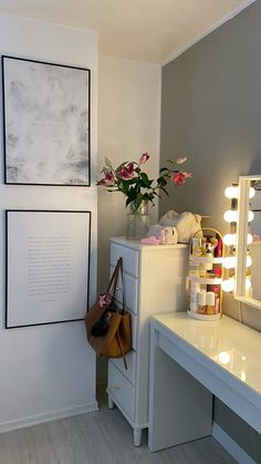 a room with a vanity, mirror and flowers on the table in front of it